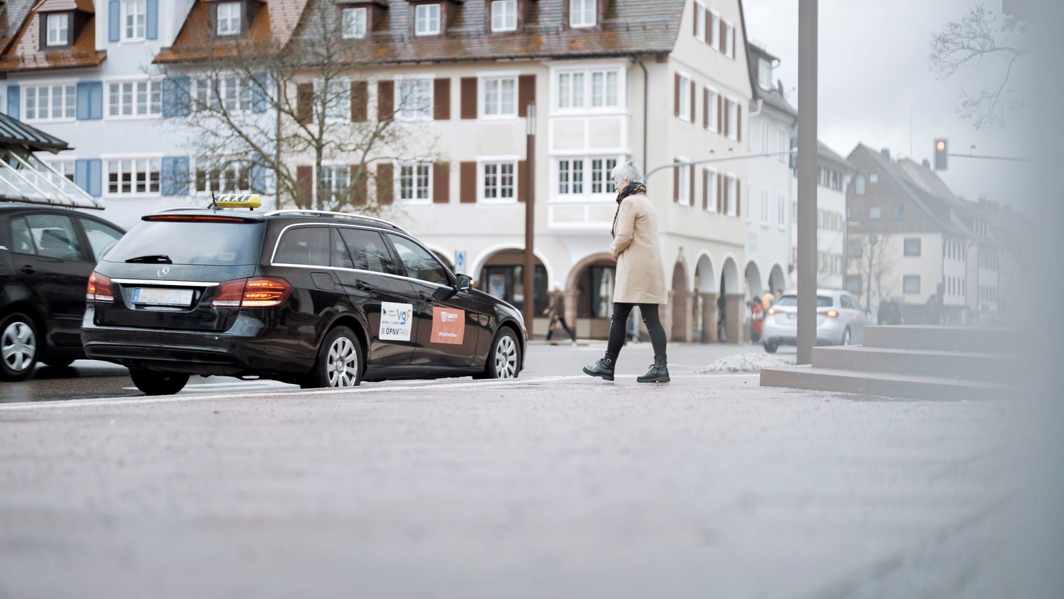 Eine Frau läuft zu einem Taxi, das am Marktplatz in Freudenstadt steht.