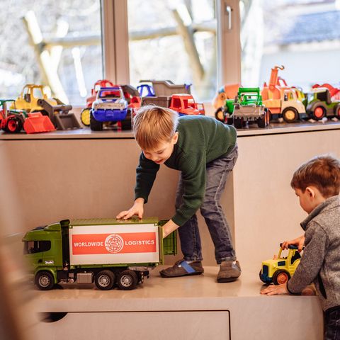 Zwei Kinder spielen mit Spielfahrzeugen in Murgels Spielhaus in Baiersbronn.