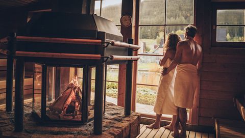 Ein Paar steht in der Sauna und schaut aus dem Fenster